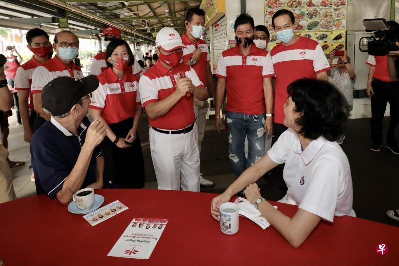 新加坡前进党秘书长陈清木医生(拱手者)为该党的丹戎巴葛集选区候选人孙俊伟(后排左起)、阿巴斯·卡斯马尼和刘韦伶助选,他在走访红山景熟食中心和巴刹时巧遇人民行动党候选人祖安清心(坐者右)。(陈斌勤摄) 新加坡前进党秘书长陈清木医生(拱手者)为该党的丹戎巴葛集选区候选人孙俊伟(后排左起)、阿巴斯·卡斯马尼和刘韦伶助选,他在走访红山景熟食中心和巴刹时巧遇人民行动党候选人祖安清心(坐者右)。(陈斌勤摄)
