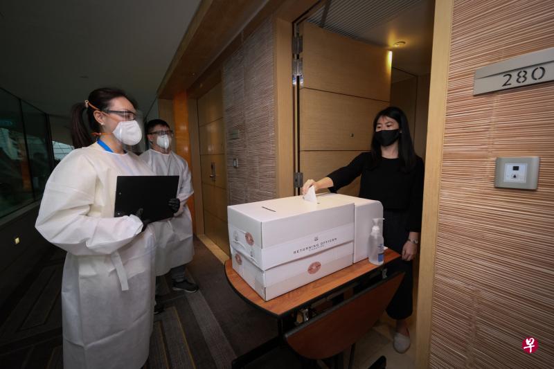 在位于滨海湾金沙的特别投票站中,监票官(左一、二)将协助履行居家通知的选民,让他们在客房门口投票。(林泽锐摄) 在位于滨海湾金沙的特别投票站中,监票官(左一、二)将协助履行居家通知的选民,让他们在客房门口投票。(林泽锐摄)