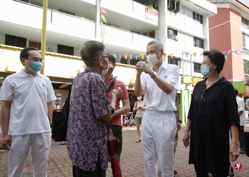 李显龙总理(右二)抱拳向选民表示感谢。(李健玮摄) 李显龙总理(右二)抱拳向选民表示感谢。(李健玮摄)