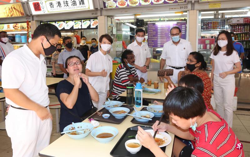 　当选西海岸区议员的人民行动党团队李智陞（白衣者左起）、胡美霞、洪维能、易华仁和王心妍昨早走访直落布兰雅熟食中心，答谢选民的支持。（庄耿闻摄）