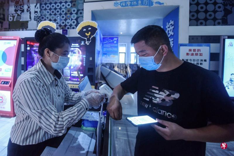 浙江杭州一家电影院复工首日,观众得先测体温才能进场。(法新社) 浙江杭州一家电影院复工首日,观众得先测体温才能进场。(法新社)
