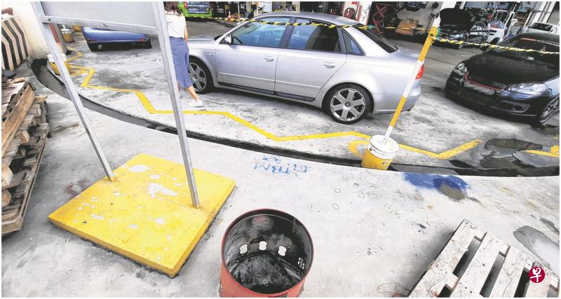 修车厂员工说,查案人员日前在修车厂外放置木架的角落翻找证据,调查了将近六小时。 修车厂员工说,查案人员日前在修车厂外放置木架的角落翻找证据,调查了将近六小时。