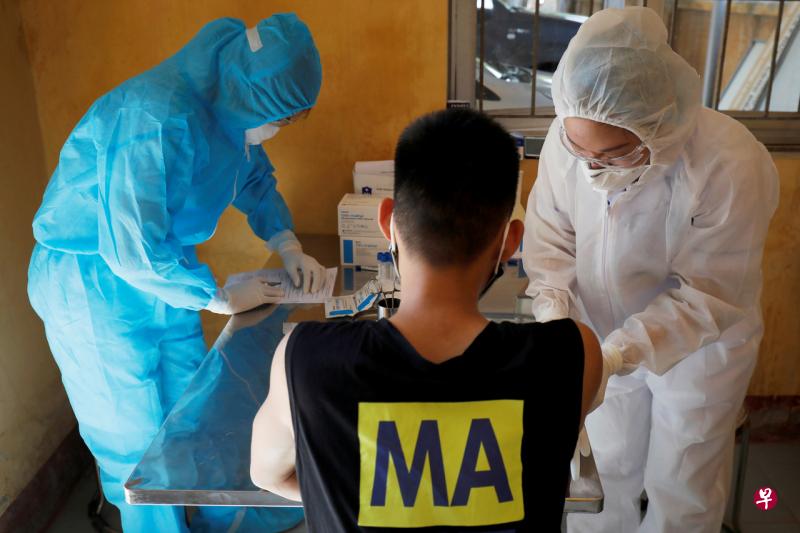 河内医护人员为一名刚从岘港返回的民众进行病毒检测。(路透社) 河内医护人员为一名刚从岘港返回的民众进行病毒检测。(路透社)