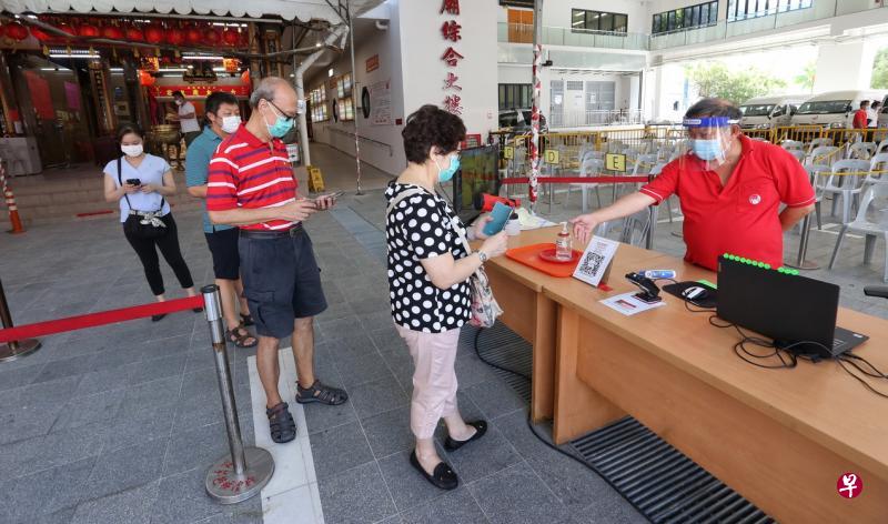 韮菜芭城隍庙的工作人员会在入口处测量访客体温,并根据庙内的人数,安排访客进入或等候。(特约陈福洲摄) 韮菜芭城隍庙的工作人员会在入口处测量访客体温,并根据庙内的人数,安排访客进入或等候。(特约陈福洲摄)
