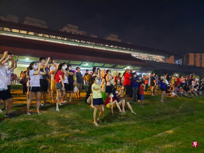 聚集在三巴旺地铁站外的居民纷纷举起手机拍照,希望把璀璨烟花记录下来。(林国明摄) 聚集在三巴旺地铁站外的居民纷纷举起手机拍照,希望把璀璨烟花记录下来。(林国明摄)