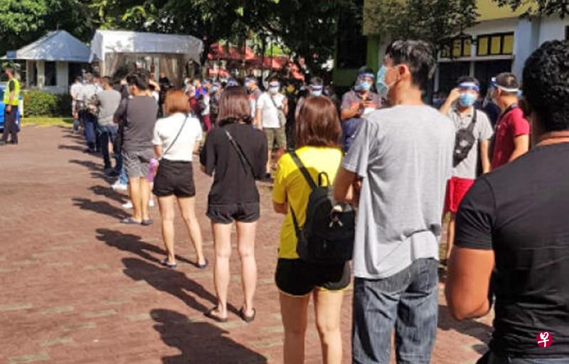 第一批从马来西亚回返新加坡工作的丰城员工于21日早上到前大侨小学接受冠病拭子检测。（丰城提供）