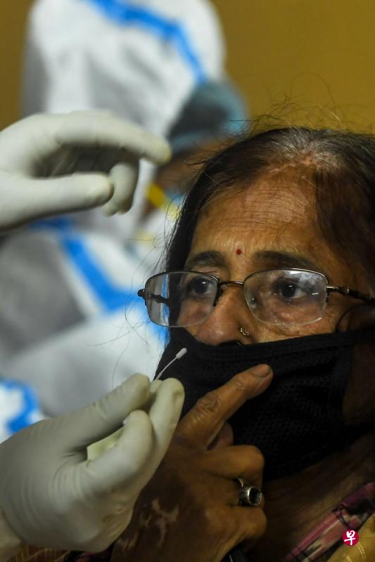 医疗人员在印度一个小镇为妇人家做冠病拭子测试。(法新社) 医疗人员在印度一个小镇为妇人家做冠病拭子测试。(法新社)