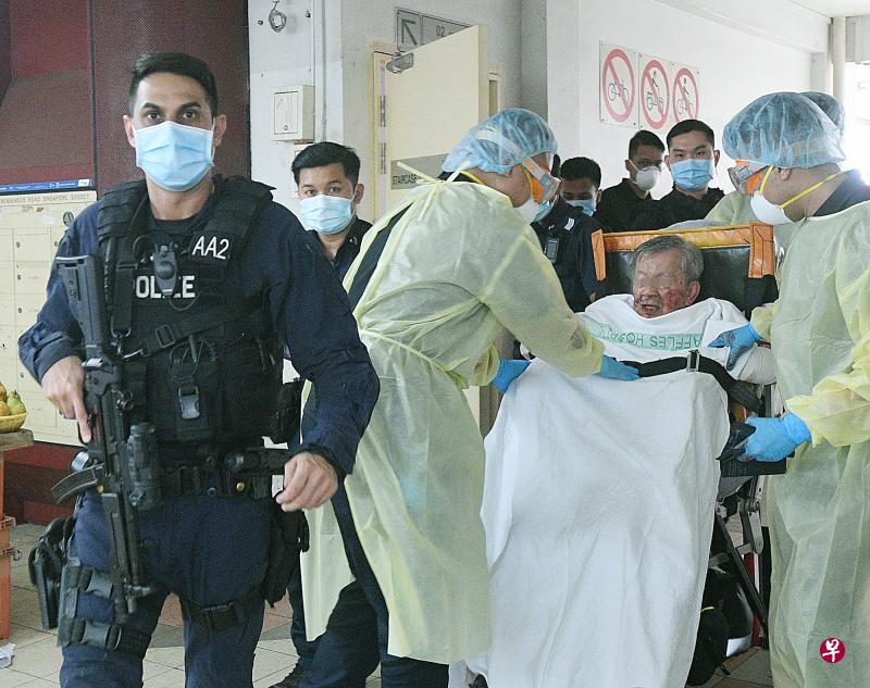 多名警员荷枪实弹押送受伤的阿伯上救护车。 多名警员荷枪实弹押送受伤的阿伯上救护车。