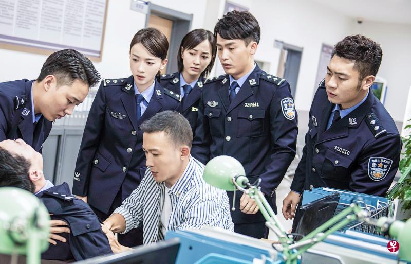 吴谨言在《幸福还会来敲门》首次演警察(后排左二),三度搭档的聂远饰演医生(前排右)。(互联网) 吴谨言在《幸福还会来敲门》首次演警察(后排左二),三度搭档的聂远饰演医生(前排右)。(互联网)