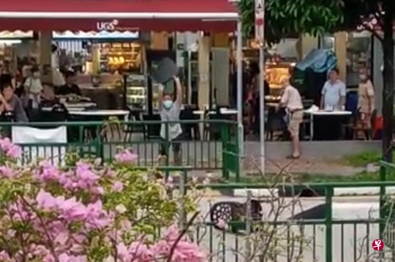 男子走到咖啡店外拿起一张椅子丢到马路上。(读者提供) 男子走到咖啡店外拿起一张椅子丢到马路上。(读者提供)