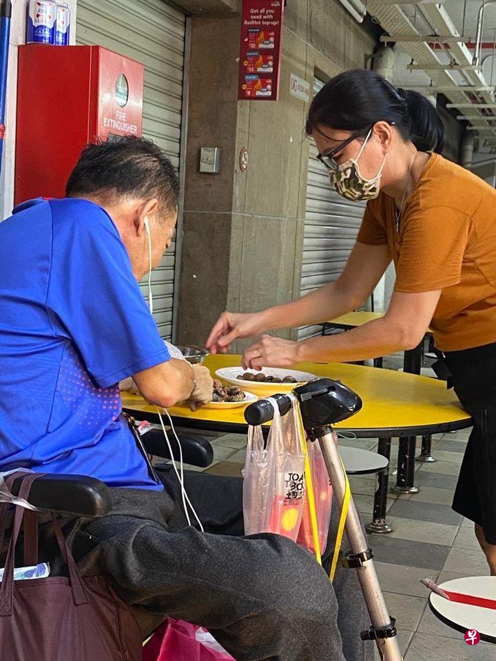 潘女士为双手不便的顾客剥血蚶，暖心一幕被拍下来。（读者提供） 