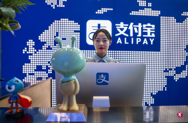 蚂蚁集团在上海的总部大厦,一名员工站在支付宝柜台前。(EPA) 蚂蚁集团在上海的总部大厦,一名员工站在支付宝柜台前。(EPA)