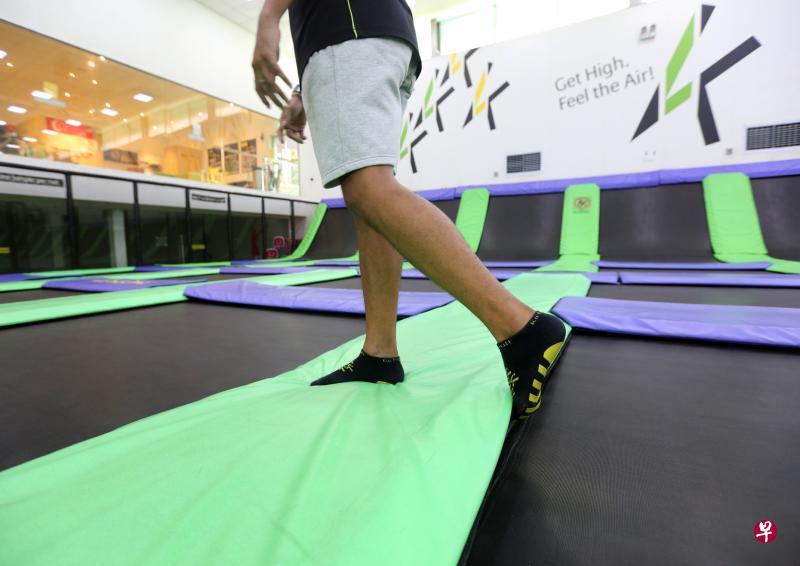 蹦床乐园经理乔尔向记者演示,事发时少女脚趾如何因勾到蹦床边缘而摔倒。(庄耿闻摄) 蹦床乐园经理乔尔向记者演示,事发时少女脚趾如何因勾到蹦床边缘而摔倒。(庄耿闻摄)