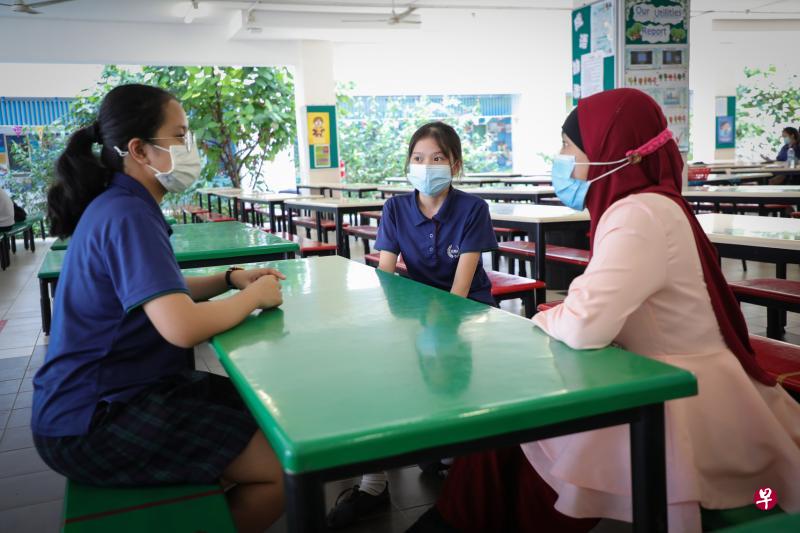 裕华中学中二生黄千瑜(中)去年修读马来语会话课,学习基本的马来语日常用语。图为她尝试用马来语与中四学姐优穆(左)和科学老师艾莎在学校食堂聊天。(林泽锐摄) 裕华中学中二生黄千瑜(中)去年修读马来语会话课,学习基本的马来语日常用语。图为她尝试用马来语与中四学姐优穆(左)和科学老师艾莎在学校食堂聊天。(林泽锐摄)