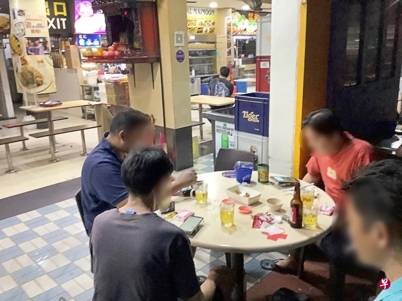 9月19日晚上10时55分,执法人员在实龙岗中通道第261座组屋咖啡店发现有两桌人在规定时间过后喝酒。(食品局提供) 9月19日晚上10时55分,执法人员在实龙岗中通道第261座组屋咖啡店发现有两桌人在规定时间过后喝酒。(食品局提供)