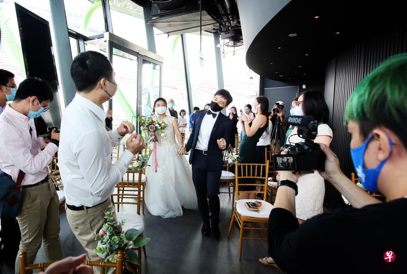 政府昨日再次宣布放宽条例,将婚礼的宾客人数限制从目前的50人提高至100人。图为今年8月8日在滨海湾公园擎天树观景台举办的一场婚礼。(档案照片) 政府昨日再次宣布放宽条例,将婚礼的宾客人数限制从目前的50人提高至100人。图为今年8月8日在滨海湾公园擎天树观景台举办的一场婚礼。(档案照片)