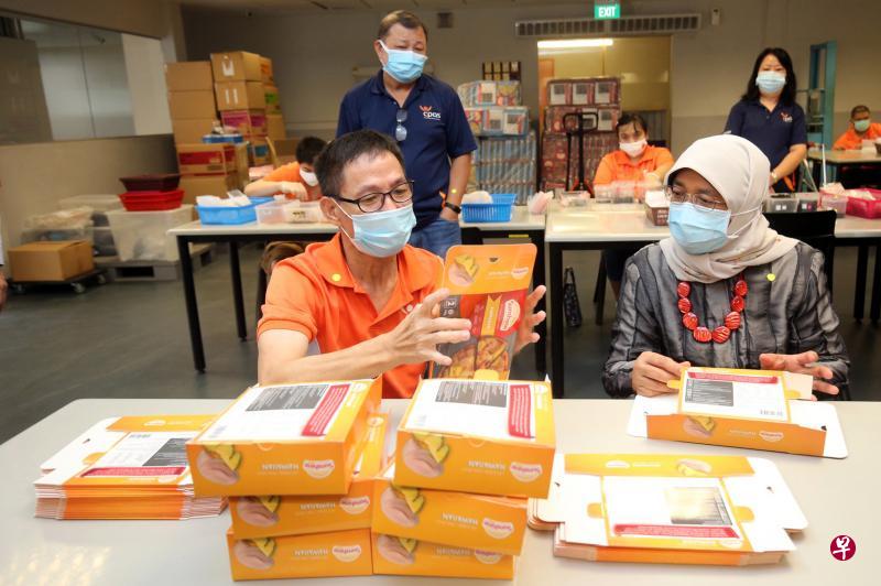 哈莉玛总统走访新加坡脑性麻痹联盟位于巴西立1道的中心，了解中心如何通过复健和职业培训计划（GROW）等项目帮助体障者提升就业能力。图为GROW学员李成东（左）向总统展示他所学的折披萨包装盒技能。（唐家鸿摄）