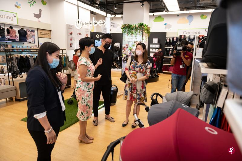 总理公署部长兼财政部和国家发展部第二部长英兰妮（左二）昨天走访位于港湾中心的Mothercare商店，同光顾该店的夫妇傅伟文（左三）和陈雅琪交谈。（特约陈佳誉摄）