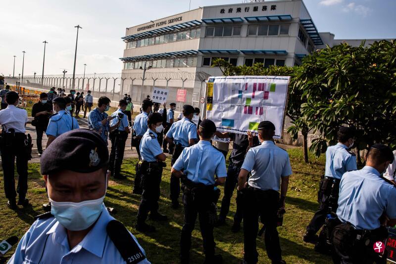 被扣押港人的家属今天在香港飞行服务队总部外抗议,警方在场戒备。(法新社) 被扣押港人的家属今天在香港飞行服务队总部外抗议,警方在场戒备。(法新社)