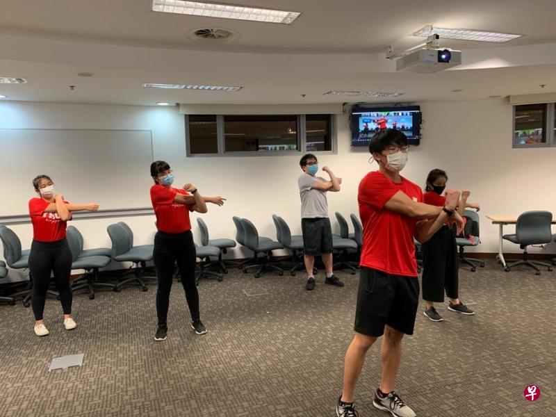 新加坡管理大学学生向线上的客工做示范,带领他们一起做暖身体操。(受访者提供) 新加坡管理大学学生向线上的客工做示范,带领他们一起做暖身体操。(受访者提供)