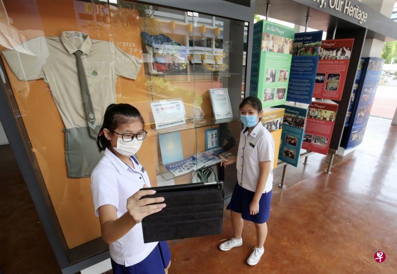 义顺中学正在探讨将海外浸濡计划转为线上。图为中三生马景怡(左)和王乐宜在学校历史走廊前练习录制视频,向海外伙伴学校的学生介绍学校历史。(邬福梁摄) 义顺中学正在探讨将海外浸濡计划转为线上。图为中三生马景怡(左)和王乐宜在学校历史走廊前练习录制视频,向海外伙伴学校的学生介绍学校历史。(邬福梁摄)