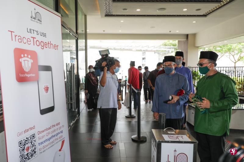 主管回教事务的社会及家庭发展部长兼卫生部第二部长马善高(右二)昨天出席尤索夫伊萨回教堂的先知穆罕默德诞辰日庆祝活动时,在进入回教堂前使用了“合力追踪”应用进行SafeEntry登记。(林国明摄) 主管回教事务的社会及家庭发展部长兼卫生部第二部长马善高(右二)昨天出席尤索夫伊萨回教堂的先知穆罕默德诞辰日庆祝活动时,在进入回教堂前使用了“合力追踪”应用进行SafeEntry登记。(林国明摄)