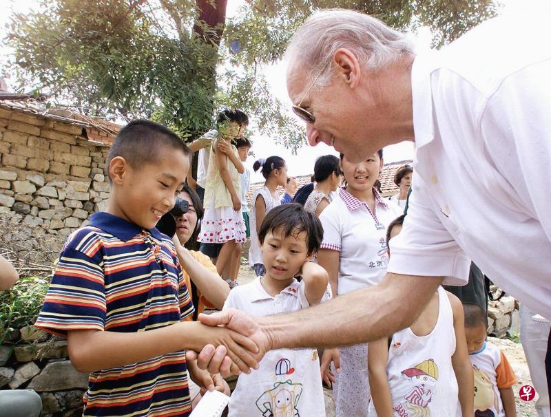 2001年8月10日,时任美国参议院外交关系委员会主席的拜登(右)在访问中国期间,在北京昌平区长陵镇燕子口村,与一名九岁男童亲切交谈。(法新社) 2001年8月10日,时任美国参议院外交关系委员会主席的拜登(右)在访问中国期间,在北京昌平区长陵镇燕子口村,与一名九岁男童亲切交谈。(法新社)