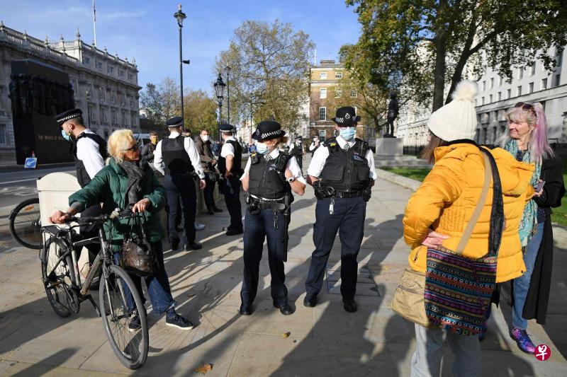 11月7日,在伦敦怀特霍尔地区执勤的警察劝说抗议第二次封锁的民众离开。(法新社) 11月7日,在伦敦怀特霍尔地区执勤的警察劝说抗议第二次封锁的民众离开。(法新社)