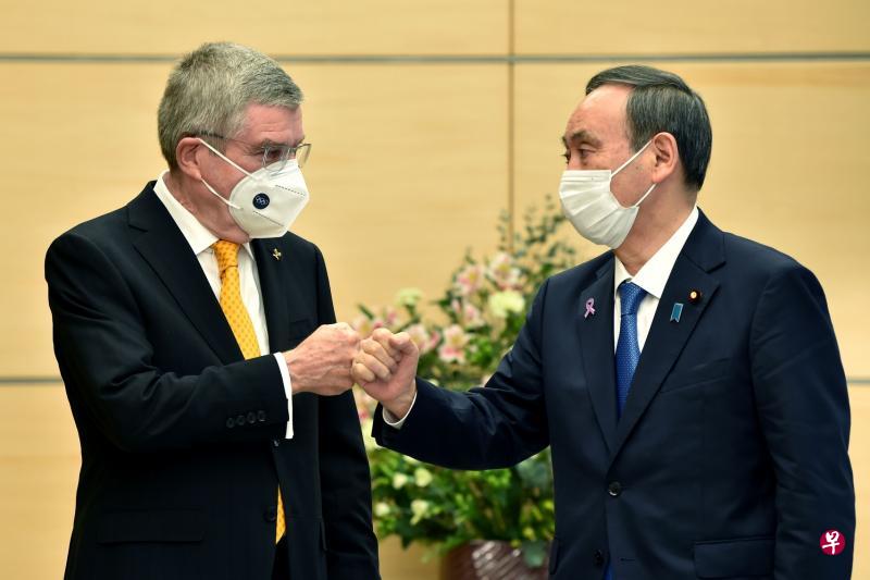 巴赫(左)与日本首相菅义伟会面时,以击拳代替握手。(法新社) 巴赫(左)与日本首相菅义伟会面时,以击拳代替握手。(法新社)