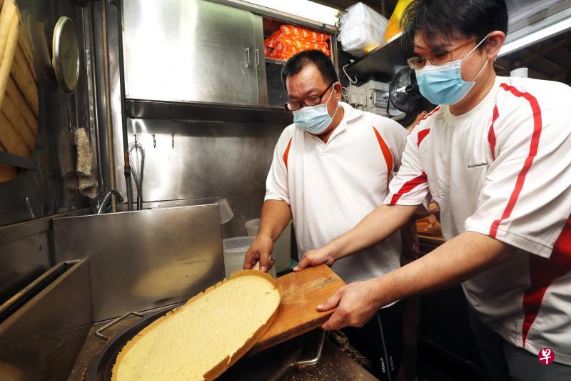 如果未来无法继续经营生意,在锦茂路第20座巴刹与熟食中心经营面煎粿生意的摊贩黄伟程(左)不介意在“小贩承前启后计划”下将生意转让给徒弟。作为黄伟程的徒弟之一,对餐饮业很感兴趣的吴德水(右)不介意接手继续售卖面煎粿。(饶进礼摄) 如果未来无法继续经营生意,在锦茂路第20座巴刹与熟食中心经营面煎粿生意的摊贩黄伟程(左)不介意在“小贩承前启后计划”下将生意转让给徒弟。作为黄伟程的徒弟之一,对餐饮业很感兴趣的吴德水(右)不介意接手继续售卖面煎粿。(饶进礼摄)