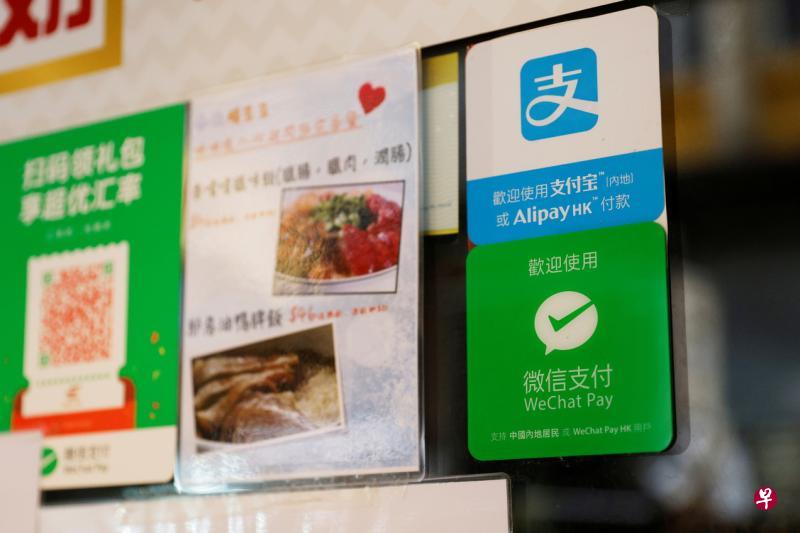 上月初香港一家餐厅玻璃门上展示了阿里巴巴的支付宝,以及腾讯的微信支付二维码,供顾客消费支付。(路透社) 上月初香港一家餐厅玻璃门上展示了阿里巴巴的支付宝,以及腾讯的微信支付二维码,供顾客消费支付。(路透社)