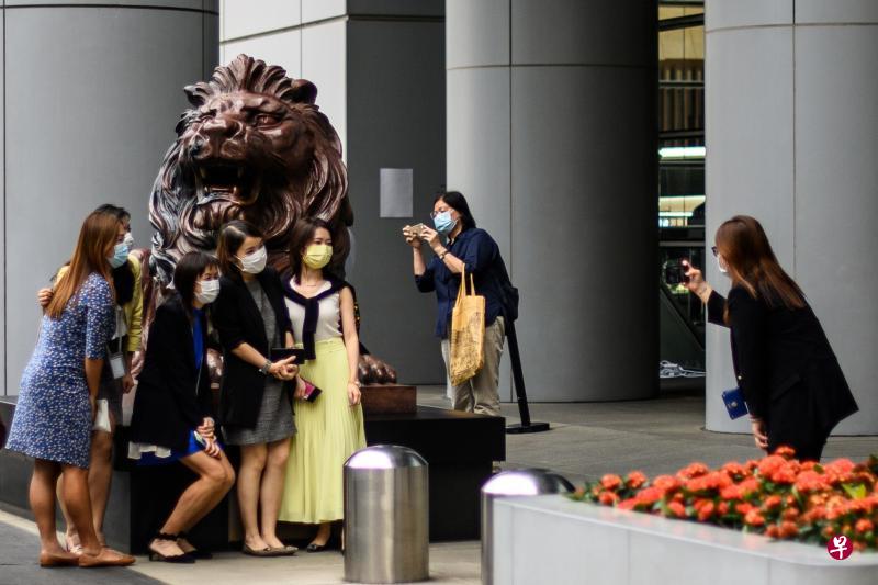 香港汇丰银行总行门外的铜狮子,经过九个月的修复工程后再度亮相。图为今年10月22日,港岛中环一群上班族与铜狮子合影留念。(法新社) 香港汇丰银行总行门外的铜狮子,经过九个月的修复工程后再度亮相。图为今年10月22日,港岛中环一群上班族与铜狮子合影留念。(法新社)
