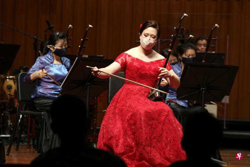 石礼晶(红衣)在新加坡华乐团驻团指挥郭勇德的指挥下,以二胡演奏一曲充满异域风情的《阿曼尼莎》,夺得卓越组冠军大奖。(邝启聪摄) 石礼晶(红衣)在新加坡华乐团驻团指挥郭勇德的指挥下,以二胡演奏一曲充满异域风情的《阿曼尼莎》,夺得卓越组冠军大奖。(邝启聪摄)