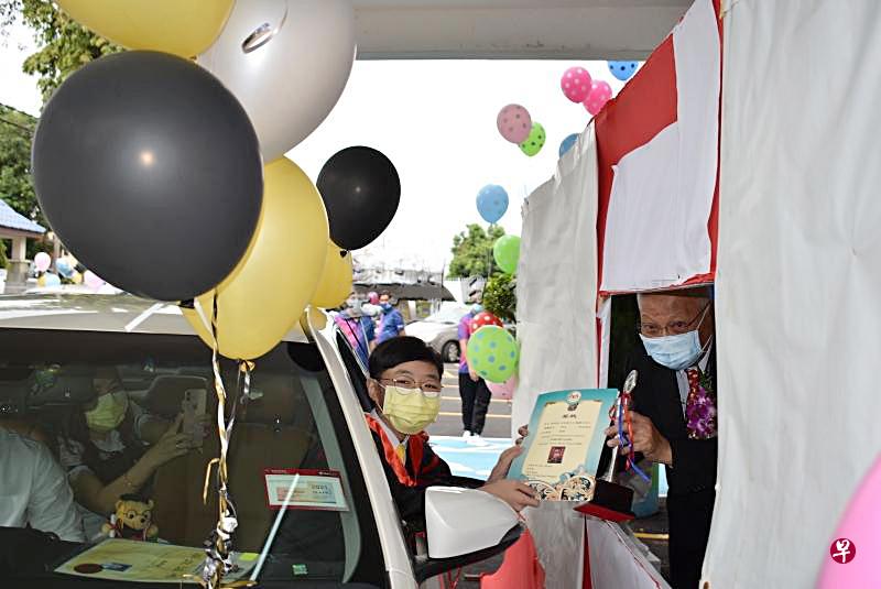 学生开心在车上接过毕业证书。(星洲日报) 学生开心在车上接过毕业证书。(星洲日报)