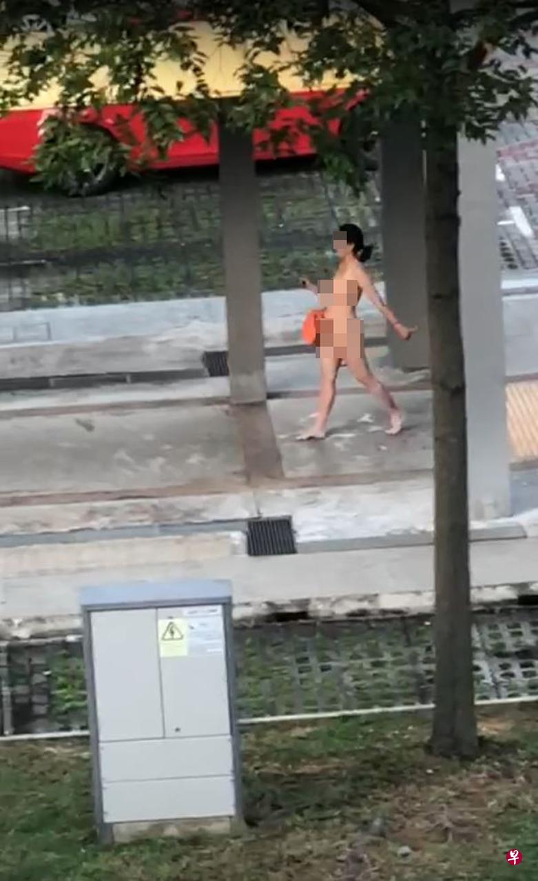 女郎除了右手提着一个橙色包包之外,全身上下一丝不挂,就连鞋子也没穿。(取自视频) 女郎除了右手提着一个橙色包包之外,全身上下一丝不挂,就连鞋子也没穿。(取自视频)
