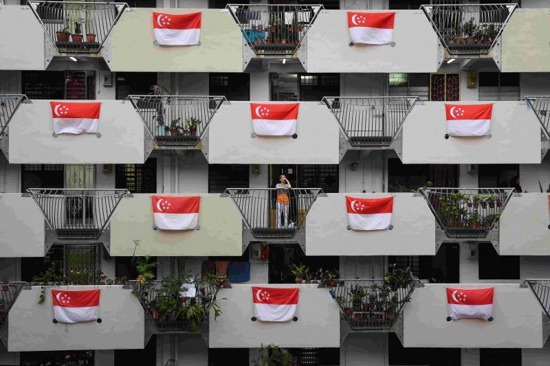 图为一组屋单位外挂上国旗庆祝我国独立日。(海峡时报档案照) 图为一组屋单位外挂上国旗庆祝我国独立日。(海峡时报档案照)