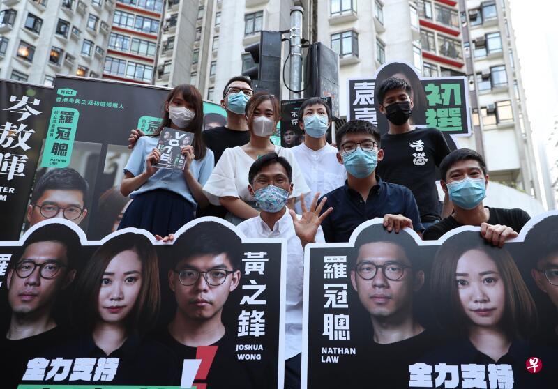 一众泛民主派人士如前香港众志成员周庭(后排左一)、前香港众志秘书长黄之锋(前排中)去年7月为泛民主派初选举行街头造势活动。(法新社) 一众泛民主派人士如前香港众志成员周庭(后排左一)、前香港众志秘书长黄之锋(前排中)去年7月为泛民主派初选举行街头造势活动。(法新社)