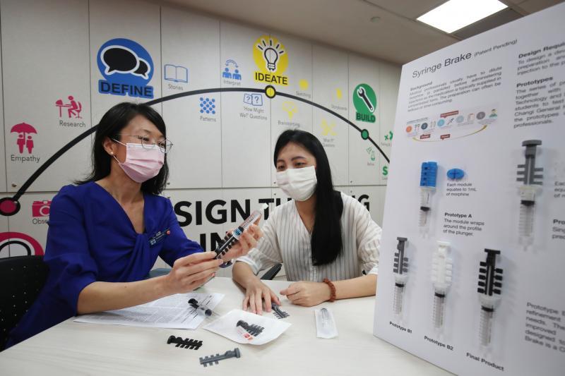在樟宜综合医院高级首席药剂师黄圆媛(左)长达八周的指导下,新加坡科技设计大学毕业生孙思齐了解医疗人员在为病人注射药物时的种种困难,经过反复讨论和改良,研发出简单且实用的针筒装置。(蔡家增摄) 在樟宜综合医院高级首席药剂师黄圆媛(左)长达八周的指导下,新加坡科技设计大学毕业生孙思齐了解医疗人员在为病人注射药物时的种种困难,经过反复讨论和改良,研发出简单且实用的针筒装置。(蔡家增摄)