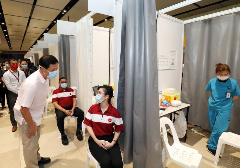 交通部长王乙康(右四)昨天到樟宜机场第四搭客大厦接种中心视察航空业前线人员的疫苗接种工作。他提到,3万7000名航空业和海事业前线员工的接种工作,预计可在两个月内完成。(邝启聪摄) 交通部长王乙康(右四)昨天到樟宜机场第四搭客大厦接种中心视察航空业前线人员的疫苗接种工作。他提到,3万7000名航空业和海事业前线员工的接种工作,预计可在两个月内完成。(邝启聪摄)