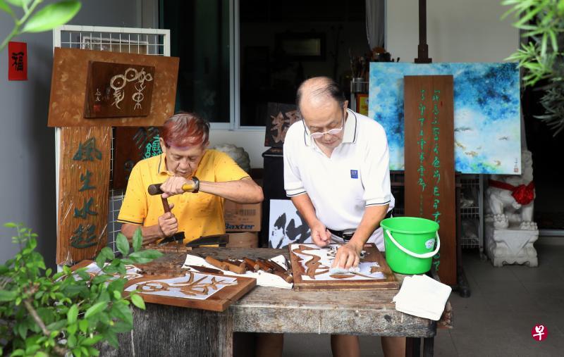 华人手工牌匾雕刻手艺去年列入我国非物质文化遗产清单。书法家杨昌泰(右)与雕刻家谢翰林,相信是本地仅有结合书法和木刻艺术的牌匾雕刻师。(严宣融摄) 华人手工牌匾雕刻手艺去年列入我国非物质文化遗产清单。书法家杨昌泰(右)与雕刻家谢翰林,相信是本地仅有结合书法和木刻艺术的牌匾雕刻师。(严宣融摄)
