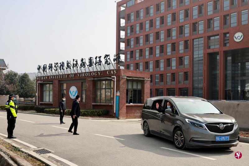 载送世卫专家组的车辆昨天驶离中科院武汉病毒研究所时，英国籍疾病生态学家达扎克向在外守候的媒体挥手。（路透社）