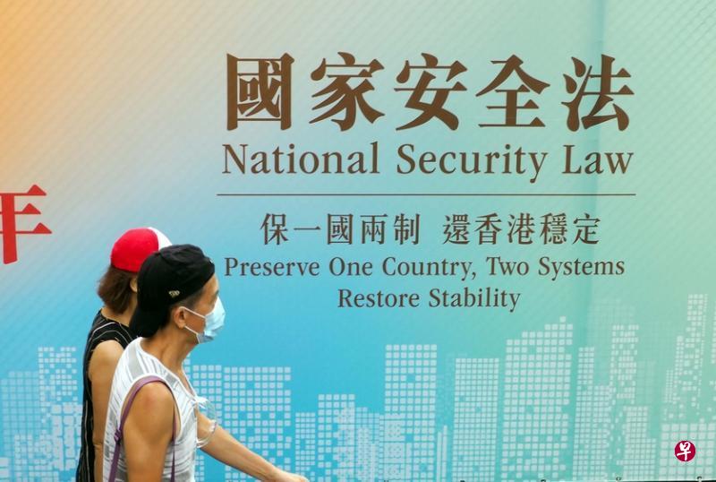 香港市民经过街头宣传“国家安全法”的标语。 (中通社) 香港市民经过街头宣传“国家安全法”的标语。 (中通社)