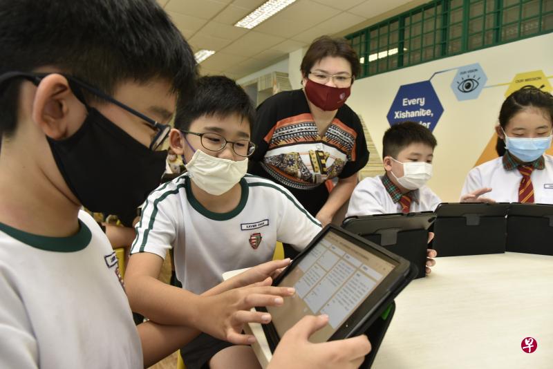 西山小学母语部主任陈秋霖(中)利用科技工具让高华学生发表作品,与同学互评,培养思辨与表达能力。(特约伍书永摄) 西山小学母语部主任陈秋霖(中)利用科技工具让高华学生发表作品,与同学互评,培养思辨与表达能力。(特约伍书永摄)