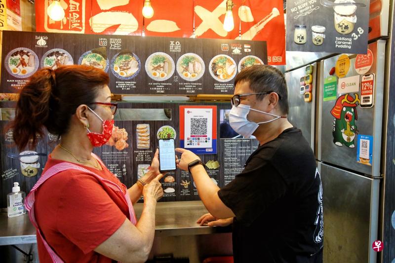 麦士威熟食中心的小贩对电子付款有疑问,都会找Tonkotsu Ramen的老板陈福顺(右)解答和帮忙,陈福顺也非常乐意协助其他小贩熟悉电子付款。(特约陈福洲摄) 麦士威熟食中心的小贩对电子付款有疑问,都会找Tonkotsu Ramen的老板陈福顺(右)解答和帮忙,陈福顺也非常乐意协助其他小贩熟悉电子付款。(特约陈福洲摄)