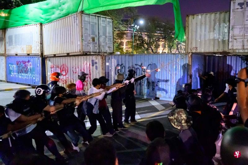 曼谷警方用集装箱阻挡示威者,但他们就用绳索把一些顶层集装箱拉倒在地。(法新社) 曼谷警方用集装箱阻挡示威者,但他们就用绳索把一些顶层集装箱拉倒在地。(法新社)