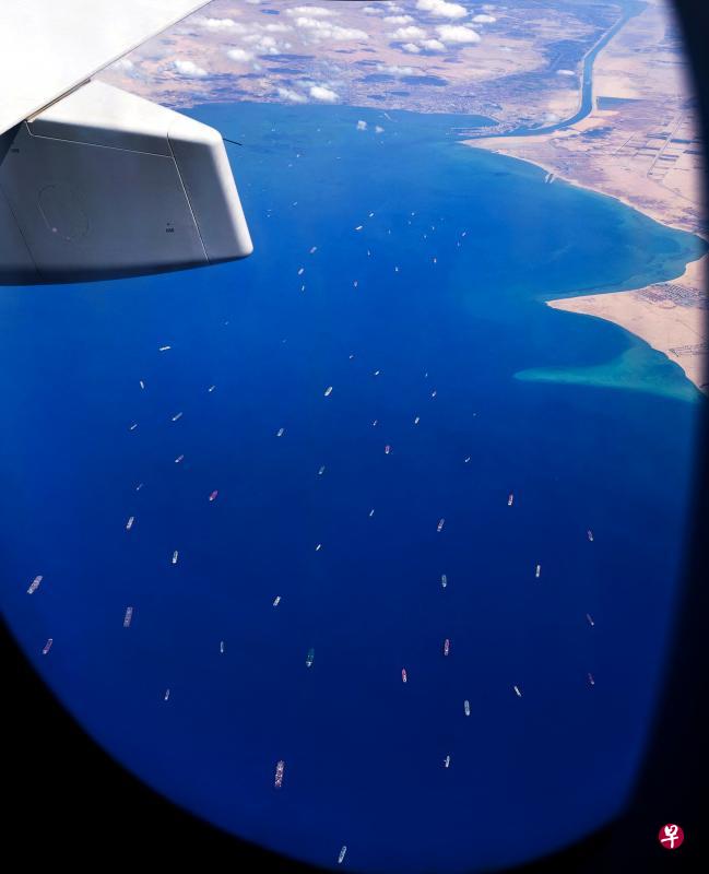 巨型集装箱船长赐号在苏伊士运河搁浅已超过四天,严重打乱了亚洲与欧洲的货运,从商用机上拍摄的画面显示,截至昨天仍有多艘货运船只在红海等待航过这条连接欧亚、世界最繁忙之一的运河。(法新社) 巨型集装箱船长赐号在苏伊士运河搁浅已超过四天,严重打乱了亚洲与欧洲的货运,从商用机上拍摄的画面显示,截至昨天仍有多艘货运船只在红海等待航过这条连接欧亚、世界最繁忙之一的运河。(法新社)