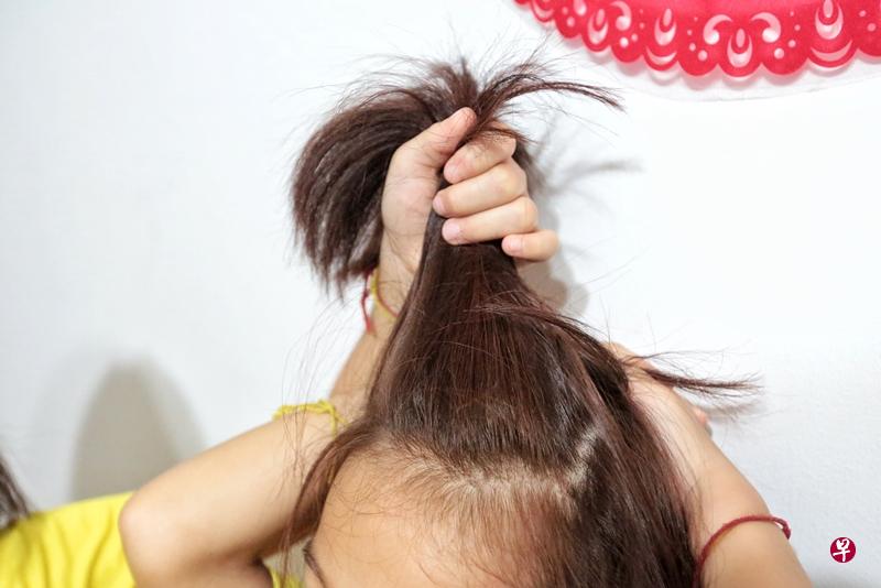 姐姐目睹妹妹被惩罚,向记者示范老师如何抓妹妹的头发。(徐颖荃摄) 姐姐目睹妹妹被惩罚,向记者示范老师如何抓妹妹的头发。(徐颖荃摄)