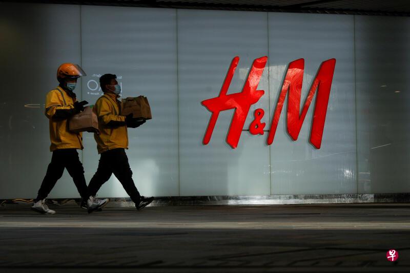 两名路人正走过H&M一家位于北京的门市。(路透社) 两名路人正走过H&M一家位于北京的门市。(路透社)