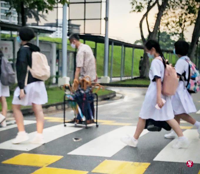 朱义顺在雨天替学生供伞。(取自网络) 朱义顺在雨天替学生供伞。(取自网络)