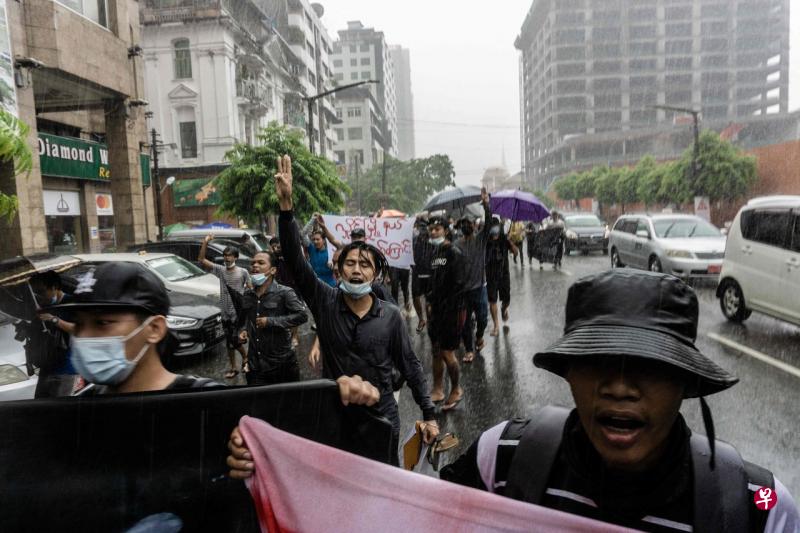 仰光周六下雨,但民众继续上街,“快闪”示威,举三指礼反对极权。(法新社) 仰光周六下雨,但民众继续上街,“快闪”示威,举三指礼反对极权。(法新社)